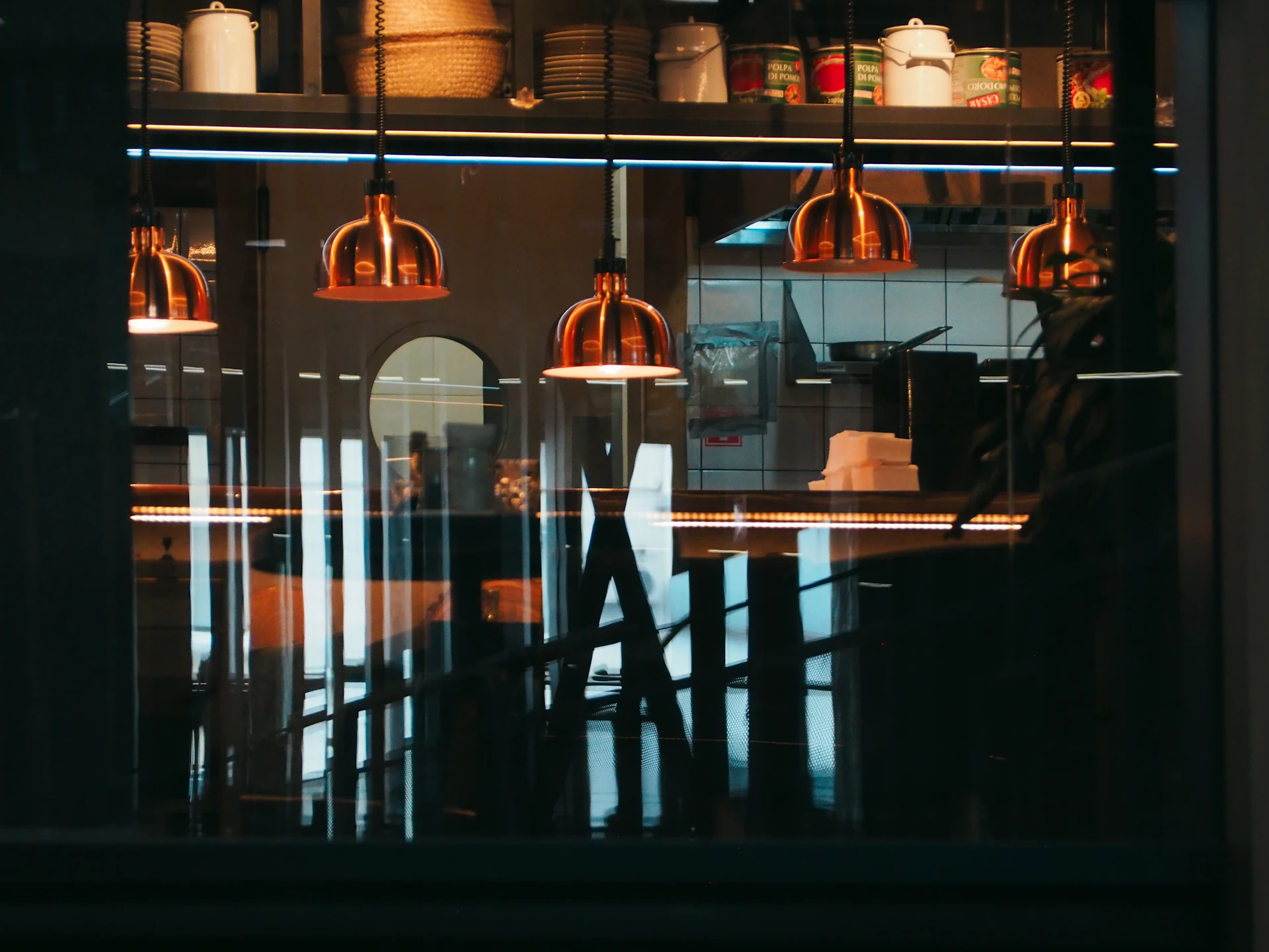 Copper pendant lights over a dim restaurant bar, restaurant payment processing by Niche Payments